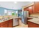 Kitchen with stainless steel appliances, granite countertops, wood cabinets, and natural light at 11510 Monon Farms Ln, Carmel, IN 46032
