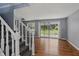 Bright living room featuring hardwood floors, sliding glass doors to the yard, and a staircase at 1240 Stringtown Pike, Cicero, IN 46034