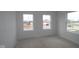 A bright unfinished bedroom features three windows offering natural light and views of the outdoors at 12403 Fresh Stock Dr, Noblesville, IN 46060