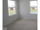 A bright bedroom features two windows offering natural light and views of the outdoors at 12403 Fresh Stock Dr, Noblesville, IN 46060