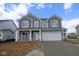 Charming two-story home featuring gray siding, a two-car garage, and a welcoming front porch at 12403 Fresh Stock Dr, Noblesville, IN 46060
