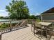 Wood deck overlooking a grassy backyard with a table and chairs and lake views on a sunny day at 13069 Abraham Run, Carmel, IN 46033