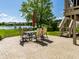 Backyard patio features outdoor seating, a red umbrella, and stunning water views and nearby greenery at 13069 Abraham Run, Carmel, IN 46033
