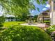 Beautiful backyard with outdoor seating, red umbrella, landscaped flowerbeds, and water views at 13069 Abraham Run, Carmel, IN 46033