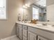 Bright bathroom featuring double sinks, white marble countertop, and a large mirror over vanity at 13069 Abraham Run, Carmel, IN 46033