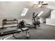 Home gym in attic space with skylights featuring weight training and cardio equipment at 13069 Abraham Run, Carmel, IN 46033
