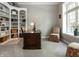 Home office featuring custom built-in bookshelves, a dark wood desk, and a cozy window nook at 13069 Abraham Run, Carmel, IN 46033