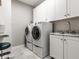 Bright laundry room features a large sink, storage cabinets, and a modern washer and dryer at 13069 Abraham Run, Carmel, IN 46033