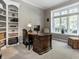 Home office featuring a large wooden desk, built-in bookshelf, and natural light at 13069 Abraham Run, Carmel, IN 46033