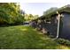 Spacious backyard with lush green grass, black brick home exterior and partial shade at 1309 Rolling Ct, Westfield, IN 46074