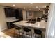 Close-up view of kitchen island with marble countertop, seating, and black cabinets at 1309 Rolling Ct, Westfield, IN 46074