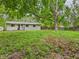 View of the home's backyard featuring a grassy lawn and mature trees providing shade and privacy at 1325 Northcrest Dr, Anderson, IN 46012