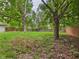 Spacious backyard with a well-kept lawn, framed by a wooden fence and mature trees for privacy at 1325 Northcrest Dr, Anderson, IN 46012