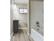 Modern bathroom featuring a gray vanity, laminate flooring, and a shower-tub combination with neutral-colored walls at 1325 Northcrest Dr, Anderson, IN 46012