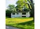 An inviting home nestled among mature trees, featuring large windows for ample natural light and a well-manicured lawn at 1325 Northcrest Dr, Anderson, IN 46012