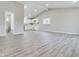 Bright living room with vaulted ceilings, light gray walls, and laminate flooring leading to a well-lit kitchen at 1325 Northcrest Dr, Anderson, IN 46012