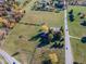 Aerial view of a large parcel of land featuring open grassy fields and trees along road frontage at 13518 (3 Lots) Promise Rd, Fishers, IN 46038