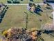 An aerial view of a large grassy lot with a small building and trees and road access at 13518 (3 Lots) Promise Rd, Fishers, IN 46038