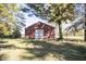 View of the large red outbuilding or barn with a white door on the property's grounds at 13518 Promise Rd, Fishers, IN 46038