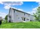 The backyard features a grassy lawn, a home with light gray siding, a white patio and a black fence at 1384 Horse Shoe, Greenwood, IN 46143