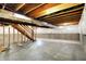 Unfinished basement view with stairwell, showing concrete flooring, and exposed beams ready for renovation at 1384 Horse Shoe, Greenwood, IN 46143
