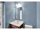 Bathroom with a white sink vanity, toilet, light fixture, and soft blue walls at 1384 Horse Shoe, Greenwood, IN 46143