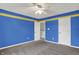 Bedroom with blue walls, ceiling fan, neutral carpet, and a white door at 1384 Horse Shoe, Greenwood, IN 46143