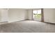 Large bedroom with neutral carpet, bright window with nature view, and white door at 1384 Horse Shoe, Greenwood, IN 46143