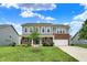 Charming two-story home featuring gray siding, brick accents, a well-manicured lawn, and an attached two-car garage at 1384 Horse Shoe, Greenwood, IN 46143