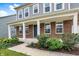 A welcoming front porch with brick accents and white columns, complemented by professionally landscaped greenery at 1384 Horse Shoe, Greenwood, IN 46143