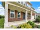 A welcoming front porch with brick accents and white columns, complemented by professionally landscaped greenery at 1384 Horse Shoe, Greenwood, IN 46143