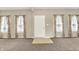Bright and airy living room features neutral walls, plush carpeting, and large windows with floral curtains at 1384 Horse Shoe, Greenwood, IN 46143