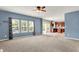 Bright living room featuring neutral carpet, blue walls, and natural light from large windows overlooking the front yard at 1384 Horse Shoe, Greenwood, IN 46143