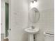 Half bathroom featuring a round mirror and a pedestal sink in a modern designed room at 15344 Cardonia Rd, Fishers, IN 46037