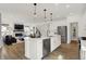 A kitchen featuring an island with seating, stainless steel appliances, and views into the adjacent living room at 15344 Cardonia Rd, Fishers, IN 46037