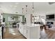 Kitchen island with quartz countertops and stainless steel dishwasher, opening into the dining and living room at 15344 Cardonia Rd, Fishers, IN 46037