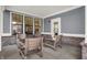 Covered patio with brick accents, modern blue siding, and four comfortable wooden chairs at 15344 Cardonia Rd, Fishers, IN 46037