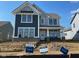 Two-story home with a mix of gray siding and brick accents under a clear blue sky in new construction neighborhood at 15360 Cardonia Rd, Fishers, IN 46037