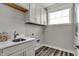 Well-lit laundry room with white cabinetry, quartz countertops, and modern sink fixtures at 15360 Cardonia Rd, Fishers, IN 46037