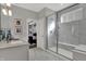 Modern main bathroom with a glass-enclosed shower, marble accents, double sinks, and an open doorway to the bedroom at 15360 Cardonia Rd, Fishers, IN 46037