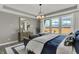 Light-filled main bedroom with a sitting area, dresser, and three large windows overlooking the neighborhood at 15360 Cardonia Rd, Fishers, IN 46037