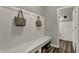 Bright mud room featuring built-in bench seating and coat hooks near a hallway leading to a powder room at 15360 Cardonia Rd, Fishers, IN 46037