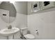 Stylish powder room with a pedestal sink, toilet, and subway tile walls accented by framed artwork at 15360 Cardonia Rd, Fishers, IN 46037