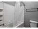 Bathroom featuring a white tiled shower-tub combination with a white shower curtain and toilet at 15596 Edenvale Dr, Westfield, IN 46074