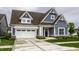 Charming home featuring blue siding, a brown roof, a white garage door and beautifully landscaped front yard at 15596 Edenvale Dr, Westfield, IN 46074