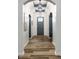 Elegant hallway showcasing arched doorways, a gray front door, modern light fixtures and sleek wood flooring at 15596 Edenvale Dr, Westfield, IN 46074