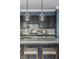 Close-up of a kitchen island with granite countertop, seating, stylish lighting, and stainless steel faucet at 15596 Edenvale Dr, Westfield, IN 46074