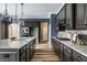 Well-lit kitchen with gray cabinets, granite countertops, stainless steel appliances, and wood floors at 15596 Edenvale Dr, Westfield, IN 46074