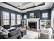 Cozy living room with a fireplace, built-in shelving, and large windows offering natural light at 15596 Edenvale Dr, Westfield, IN 46074