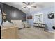 Stylish Bedroom with blue walls, gray accents, crib, rocker, and ceiling fan at 170 W Broadway St, Greenwood, IN 46142